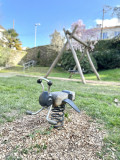 Aire de jeux du Jardin de Gourmalon avec jeu en bois sur ressort en forme d'abeille